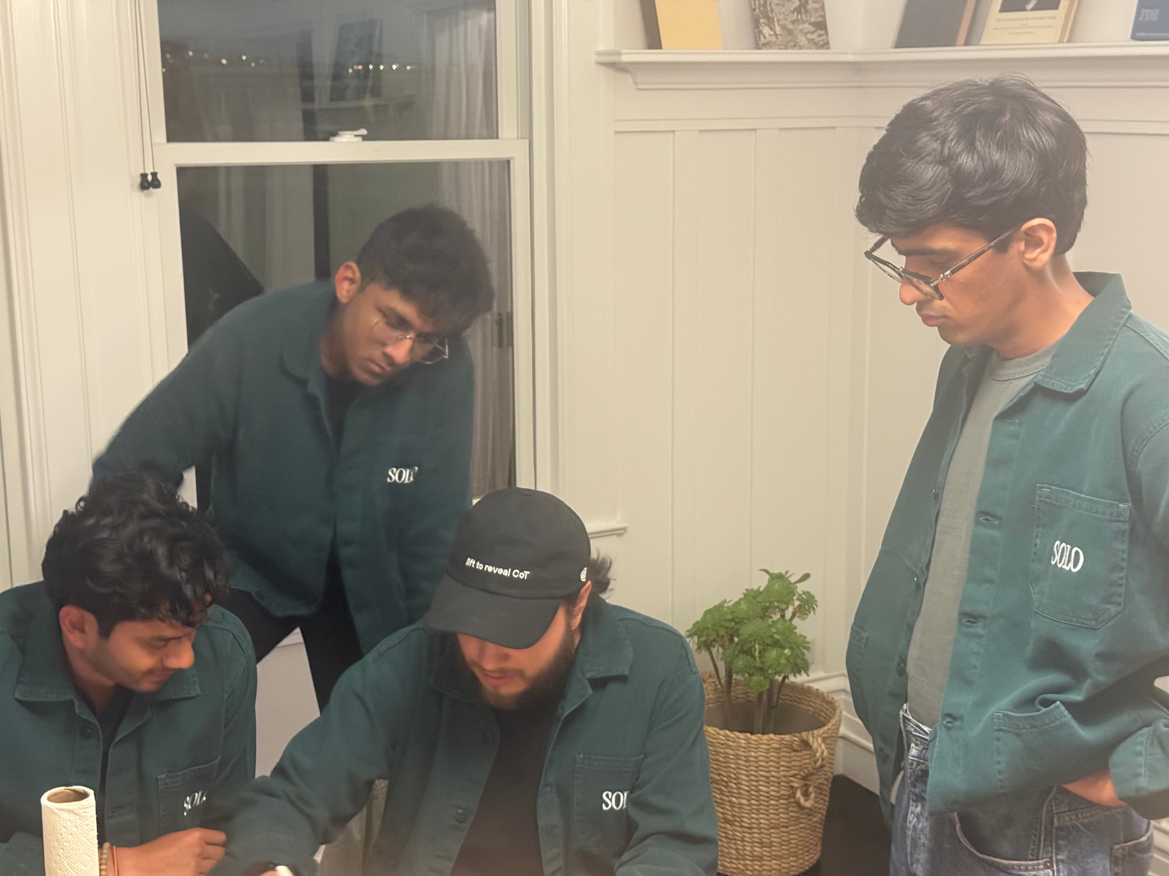 Founders huddled around a laptop, working through a problem together
